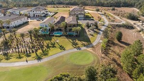 A residential area with multiple houses, a golf course, and a swimming pool.
