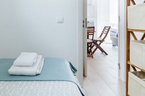 Una camera d'albergo con un letto, una sedia e vista all'esterno.