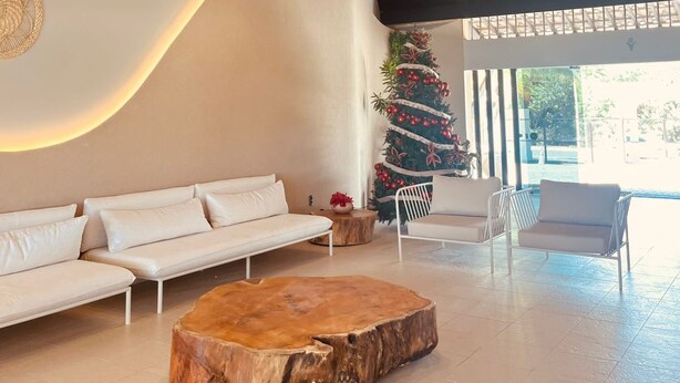 A modern interior with a wooden coffee table, white sofas, and a Christmas tree. - Marupiara Flat, equipped, free Wi-Fi and parking, best part of the beach (N. São do Ó)