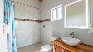 A bathroom with a shower, toilet, sink, and mirror. - Loggerhead - 2BR House at Secret Beach (San Pedro)