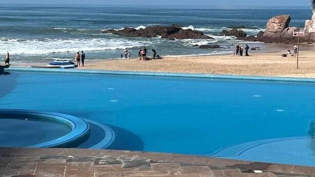 Piscina com vista para o oceano e a praia.