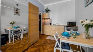 Una cocina moderna con armarios de madera, un microondas y un comedor con mesa y sillas.