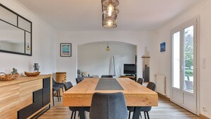 Una cucina moderna con un tavolo e sedie in legno, un'ampia finestra e un modellino di una barca a vela.