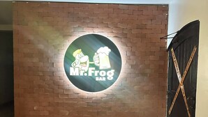 A brick wall with a circular logo for 'Mr. Frog Bar' and a tiled floor. - Coronado Luxury Club & Suites -swim up suite with Golf for 2 with club amenities (Panamá Oeste Province)