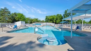 A swimming pool with lounge chairs and a covered area. - Expansive Lake-Access Condo with Tranquil Views, Community Pool, Mini Golf & Free Daily Tickets (Kimberling City)