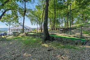 A park with a green walking path, benches, and a building in the background.