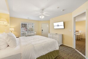 Een hotelkamer met een bed, bureau, stoel, televisie en raam.