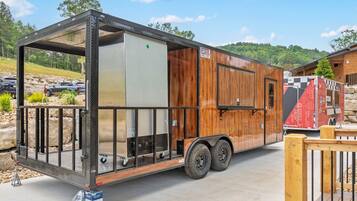 A mobile home with a metal frame, wooden exterior, and a sliding door.