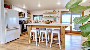 A modern kitchen with white appliances, wooden countertops, and bar stools. - Charming Lakefront Home~Hot Tub~Fire Pit~Large Covered Deck (Fayetteville)