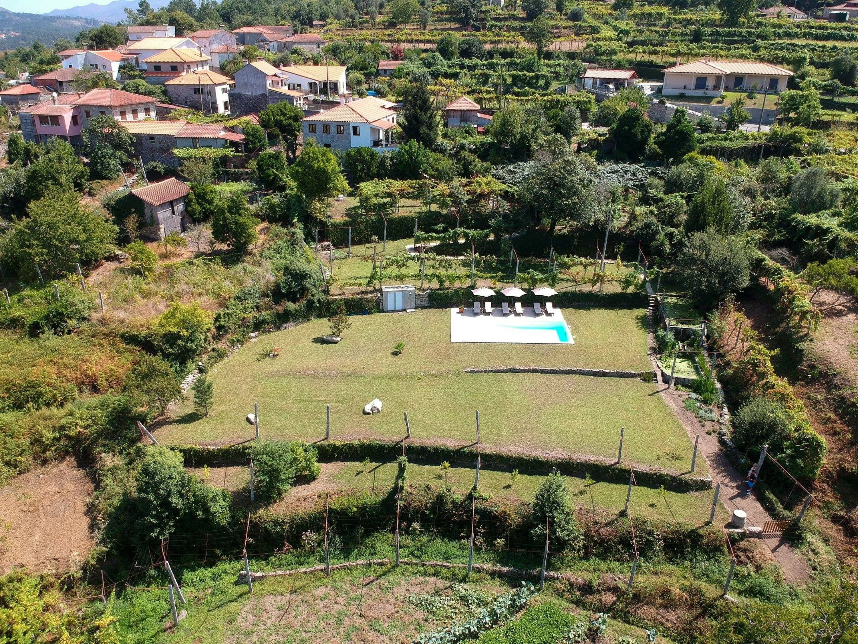 A residential area with houses, a swimming pool, and a fenced garden.