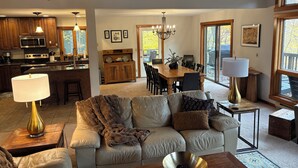 Ein geräumiges Wohnzimmer mit einer Couch, einem Couchtisch und einem Essbereich mit einem Holztisch und Stühlen.