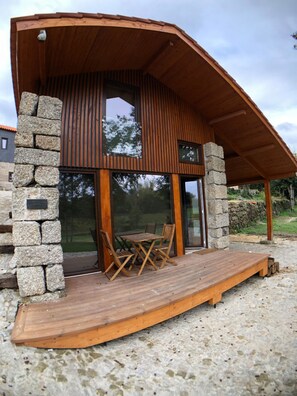 A modern building with a wooden deck, stone walls, and large windows. - Vila Alambique in Bustelo (Penafiel)