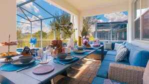 Un área de comedor al aire libre con cerramiento de vidrio, mobiliario azul y decoración temática de Star Wars.