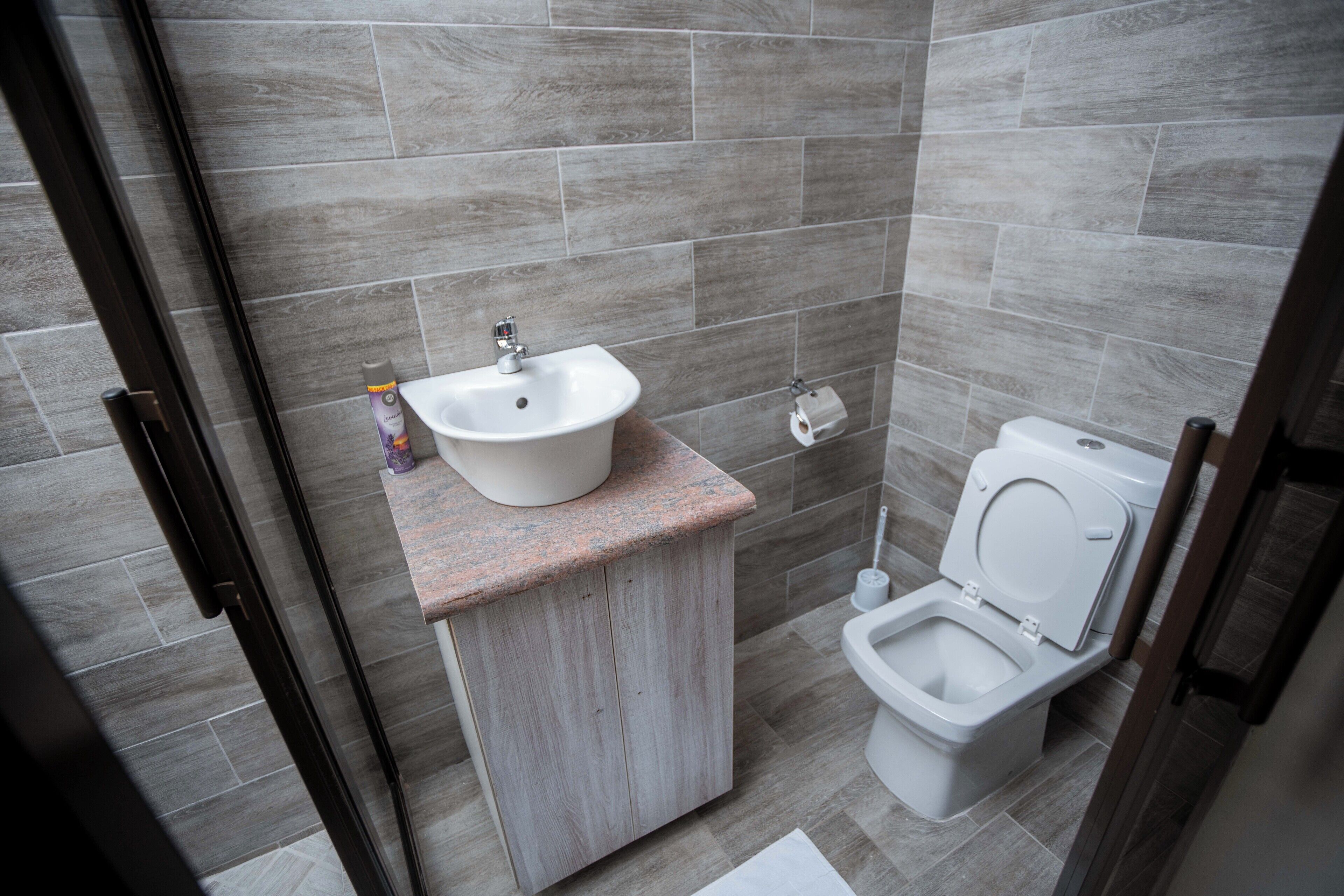 Ein modernes Badezimmer mit Waschbecken, Toilette und Duschbereich.