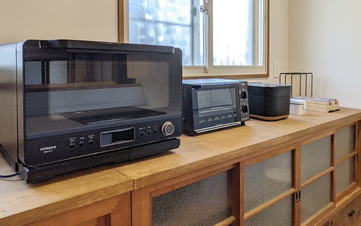A kitchen with a microwave, toaster, and coffee maker on a wooden countertop.