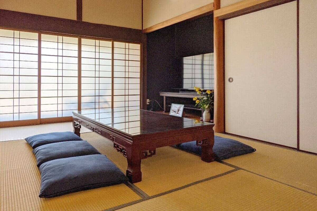 A traditional Japanese room with tatami flooring, a low wooden table, and shoji screens.