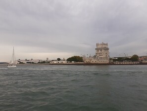 A historic tower by the waterfront with a sailboat in the foreground. - Lisboa - Benfica Est dio da Luz Apartment (Lisbon)