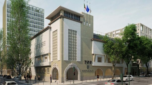 A modern building with a prominent entrance, a flag, and a sign indicating it is the Portuguese Embassy.