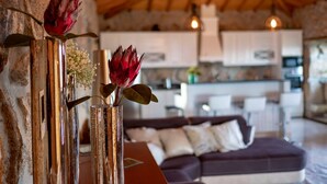 A modern living room with a stone wall, a wooden ceiling, and a sofa. - Luxury Villa Private Pool Belle Poque (Celorico de Basto)