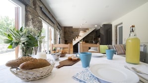 A breakfast setting with bread, pastries, and a bottle of juice on a table. - Vila Beiral in Penafiel (Penafiel)