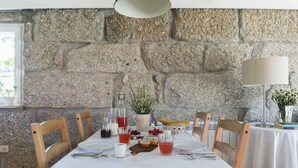 A dining table set with plates, cutlery, glasses, and a variety of food items. - Vila Caseiro in Bustelo (Penafiel)