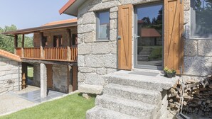 A stone building with a wooden balcony and a staircase leading to the entrance. - Vila Caseiro in Bustelo (Penafiel)
