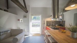 Et moderne køkken med træbordplade, indbygget komfur og et stort vindue.