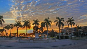 A sunset view with palm trees and a gazebo in a landscaped area. - Guesthouse by the Beach (Fort Pierce)