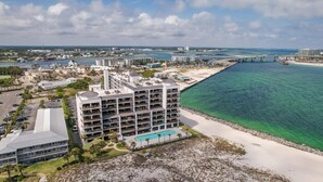 Un hotel de varios pisos con balcones, piscina y vista al mar.