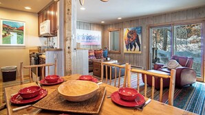 A cozy dining area with wooden furniture, a large wooden table, and red plates. - Andora Alpine Retreat - 2BD in downtown Ketchum (Ketchum)