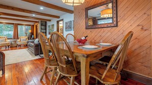 A dining area with a wooden table and chairs, a chandelier, and a mirror on the wall. - Portage Lakes, Lakefront, Private Dock & Deck (Akron)