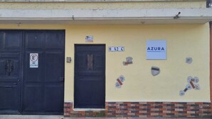 Un edificio con dos puertas negras, un letrero que dice "AZURA HOTEL" y el número "842 C" en la pared.