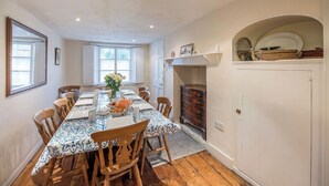 A dining room with a long table, chairs, a fireplace, and a window. - Varley House, Saxmundham (Saxmundham)