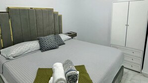 Ein modernes Schlafzimmer mit Bett, Nachttisch und Kleiderschrank.