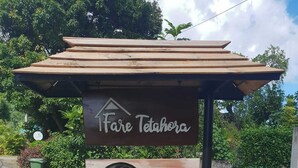 Une enseigne indiquant un hôtel nommé « Fãre Tetahora », avec un numéro de téléphone à contacter.