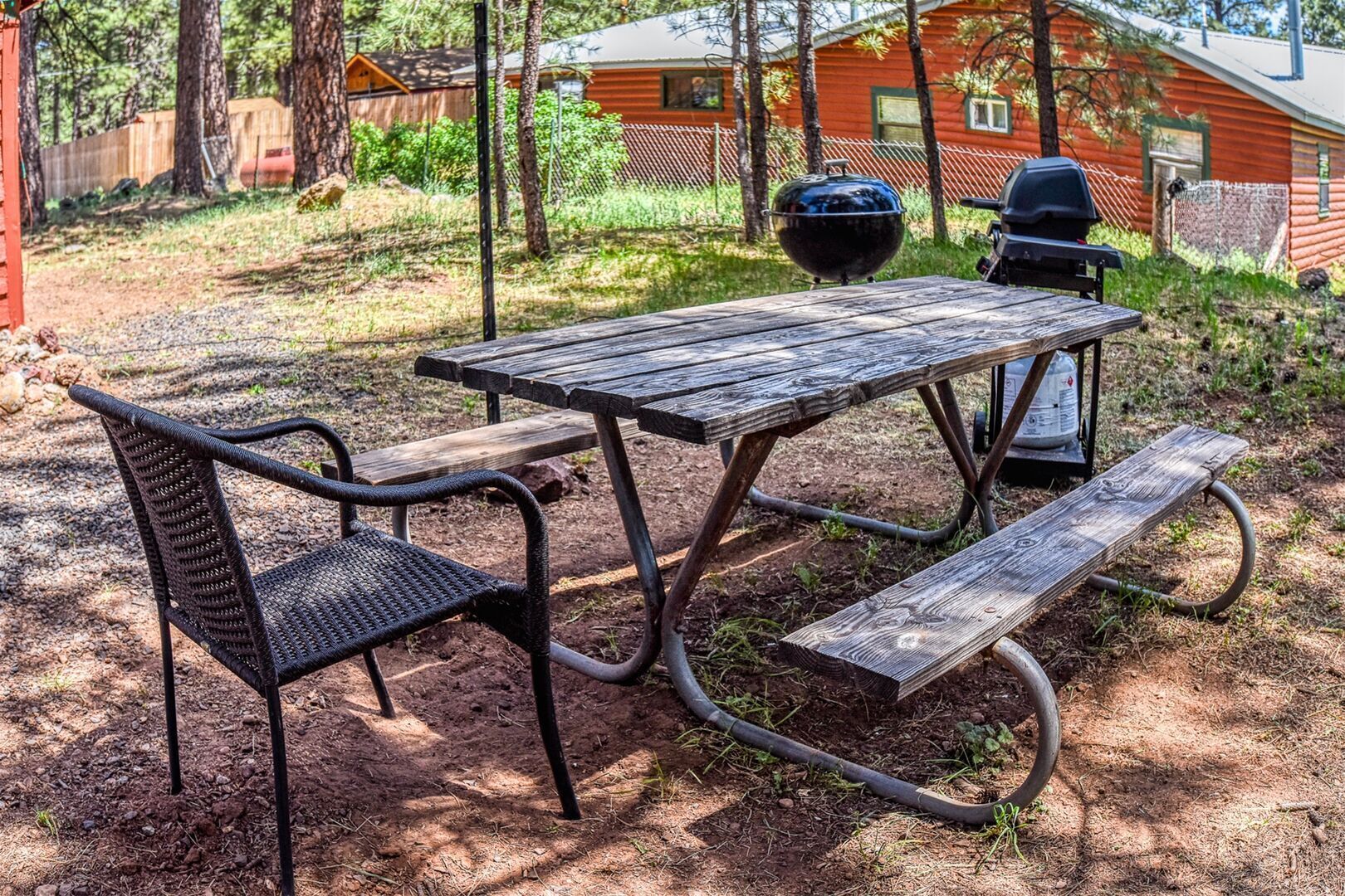 Et picnicbord med bænke i et skovområde.