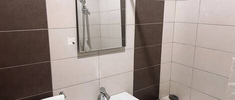 Een douche, handdoeken, zeep, toiletpapier