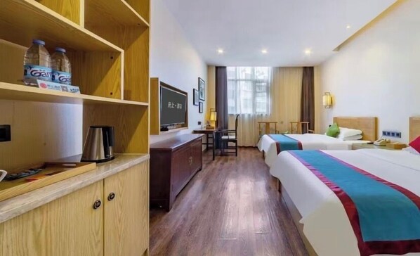 A hotel room with two beds, a desk, a television, and a minibar. - Fushang Hotel (Chenzhou Yuhou Street Nanta Park) (Chenzhou)
