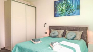 A bedroom with a bed, pillows, a blanket, and a painting on the wall. - Villa Temelia by Interhome (Rovinj/Žminj)