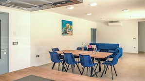 A modern dining area with a wooden table, blue chairs, and a blue sofa. - Villa Temelia by Interhome (Rovinj/Žminj)