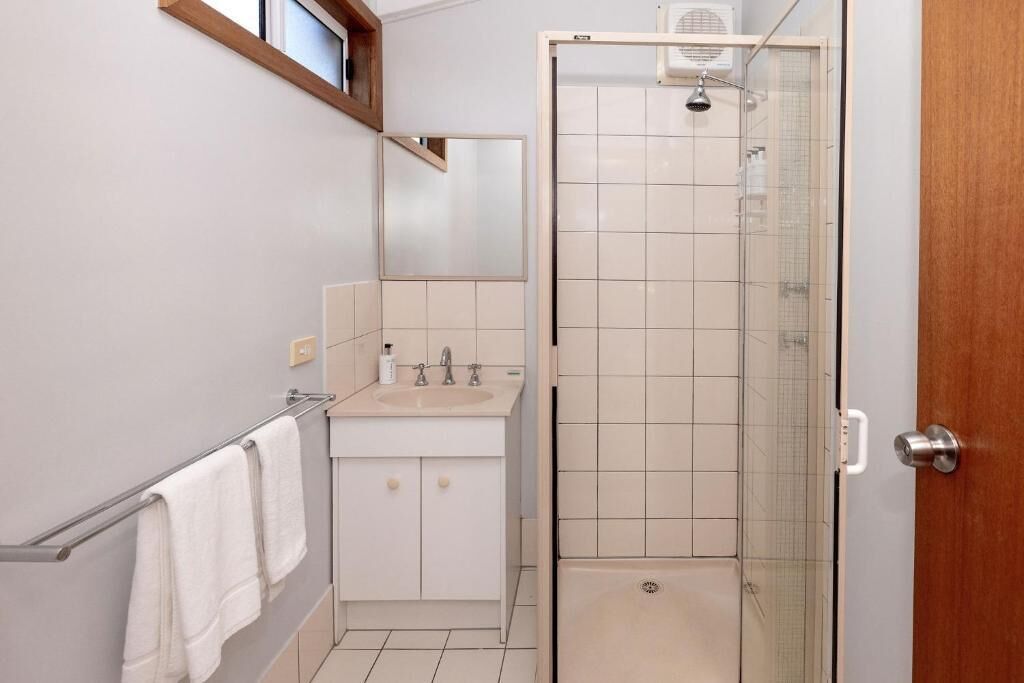 Une salle de bain avec un lavabo, un miroir et une douche.