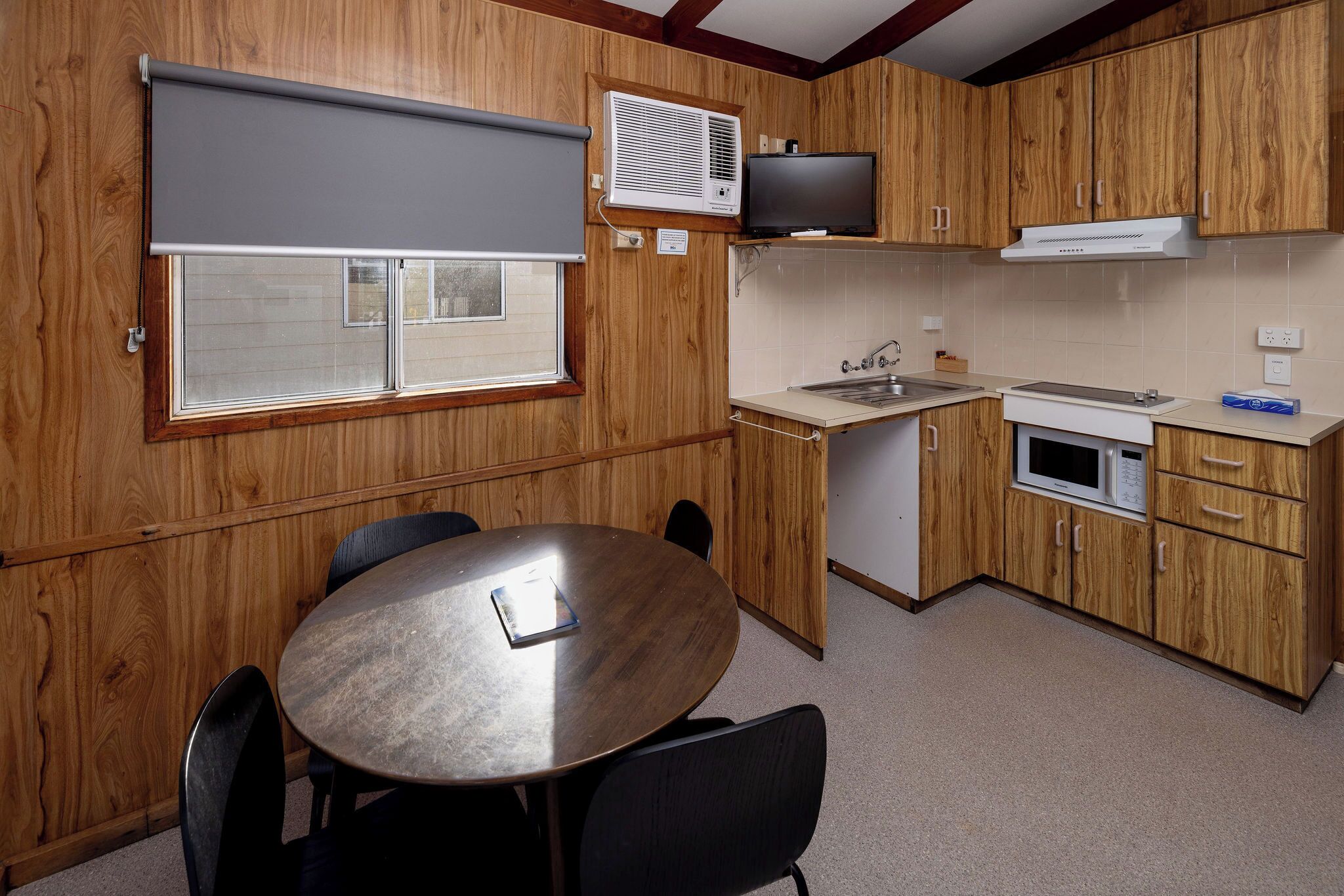 A kitchen with wooden cabinets, a microwave, a stove, and a sink.