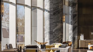 Een modern interieur met grote ramen, marmeren zuilen en eigentijds meubilair.