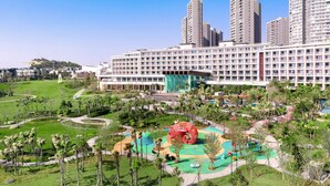 Ein Hotel mit großem Außenbereich, inklusive Spielplatz und einer auffälligen, roten Spiralplastik.