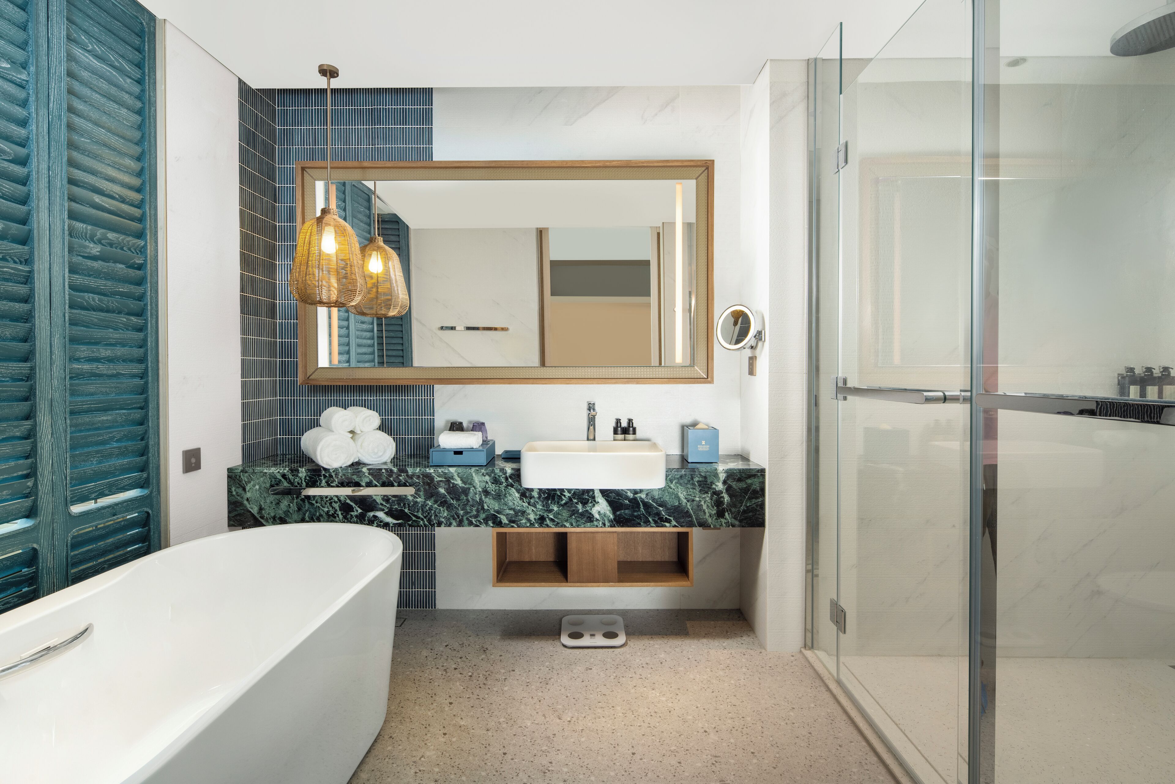 Een moderne badkamer met een vrijstaand bad, een grote spiegel en een douchecabine van glas.