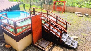 A swimming pool with a wooden deck and a small wooden staircase leading to a covered area. - Mystic River Retreat | 3BR/2BA•Pool - Jacuzzi - Beverly Hills, Guaynabo, Guaynabo, Puerto Rico (Guaynabo)