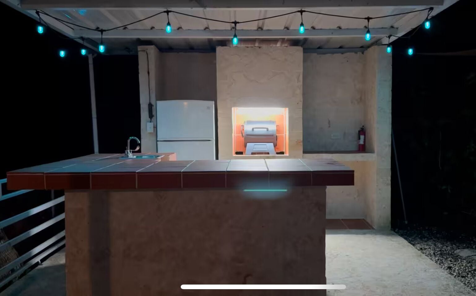 A kitchen with a central island, a refrigerator, and a sink.