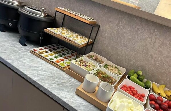 Una barra de buffet con diversos alimentos y bebidas.
