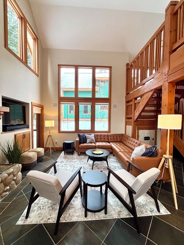 TV connectée, cheminée, livres, chaîne hi-fi