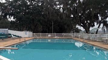 A rectangular swimming pool with a white fence and no diving board.